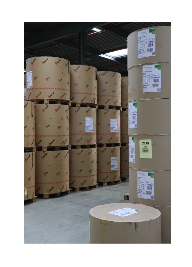 Voorraad van grote rollen MC papier, geschikt voor rotatiepersen en hoogwaardige printproductie.