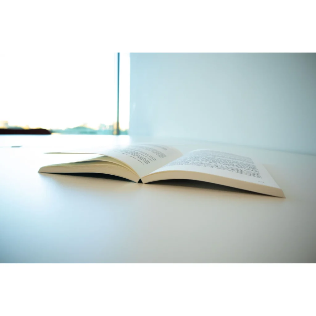 Openliggend roman boek op tafel in modern, licht interieur.